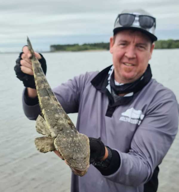 Jed Young holding a flathead caught on a longtail soft plastic from LandCaster Tackle.